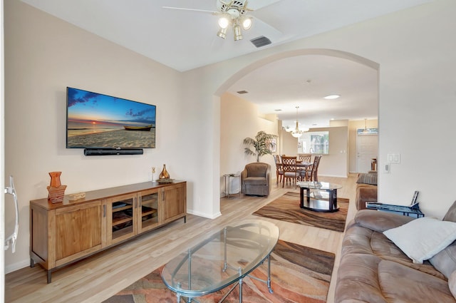 living room with light hardwood / wood-style flooring and ceiling fan