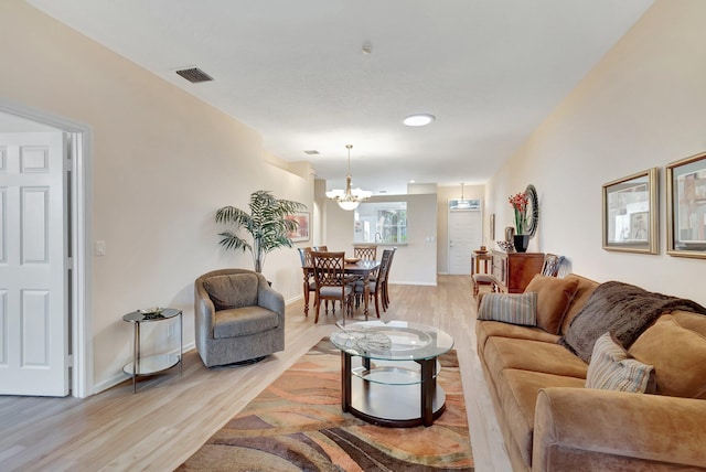 living room featuring an inviting chandelier and light wood-type flooring