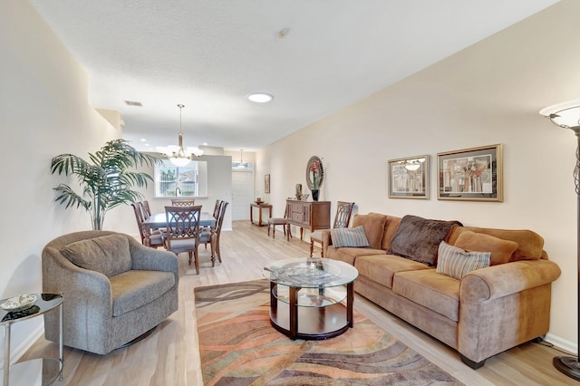 living room with a chandelier and light hardwood / wood-style floors