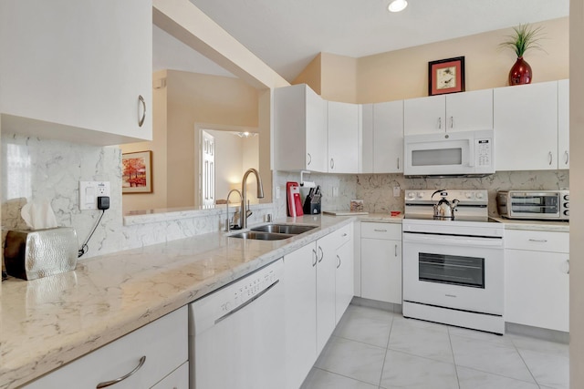 kitchen with sink, white appliances, tasteful backsplash, light stone countertops, and white cabinets