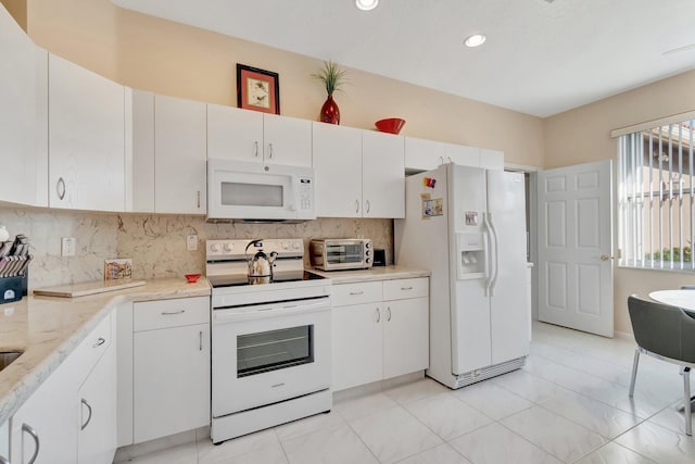 kitchen featuring tasteful backsplash, white appliances, light stone counters, and white cabinets