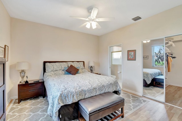 bedroom featuring ensuite bath, light hardwood / wood-style floors, and ceiling fan