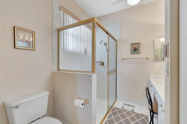 bathroom featuring vanity, an enclosed shower, and toilet