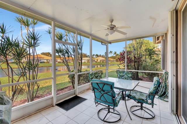 sunroom / solarium with a water view, a healthy amount of sunlight, and ceiling fan