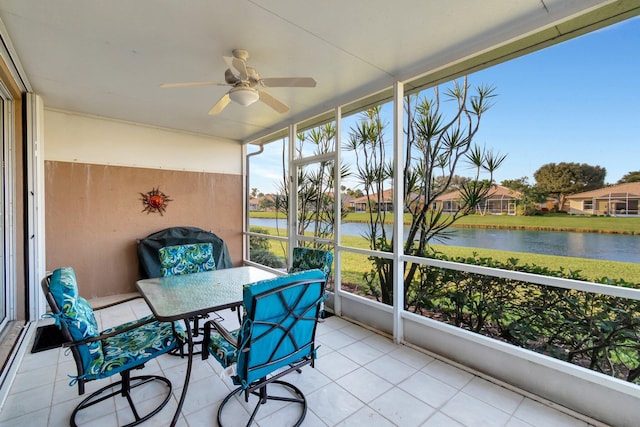 sunroom with a water view and ceiling fan