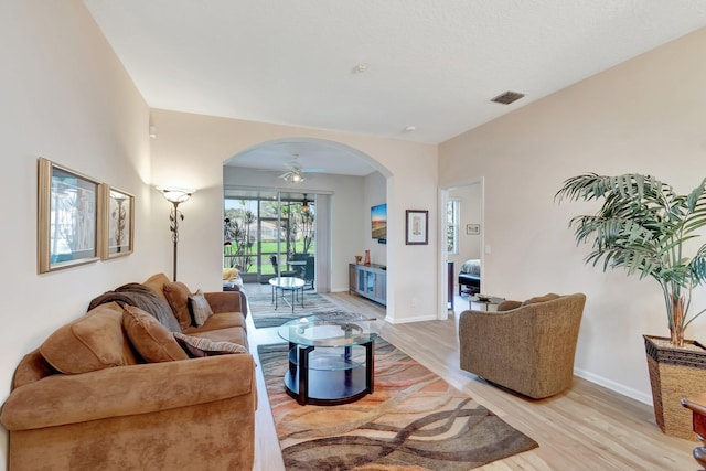 living room with light hardwood / wood-style flooring and ceiling fan