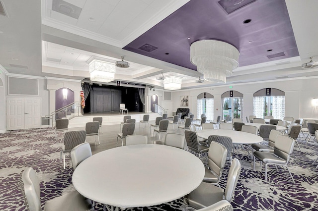 carpeted dining room featuring decorative columns, ornamental molding, an inviting chandelier, and a tray ceiling