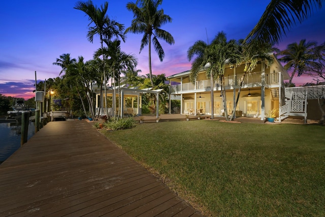 dock area featuring a pergola, a balcony, and a lawn