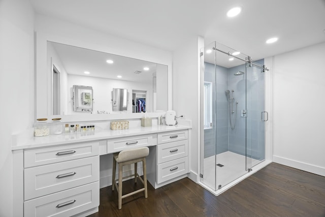 bathroom with hardwood / wood-style flooring, vanity, and a shower with shower door