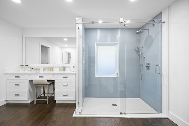 bathroom featuring a shower with shower door, wood-type flooring, and vanity