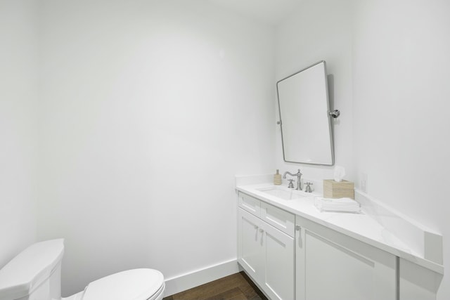 bathroom featuring vanity, hardwood / wood-style flooring, and toilet