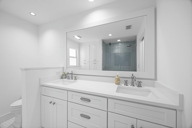 bathroom featuring vanity, toilet, and a shower with door