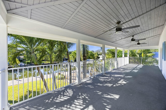 view of patio / terrace featuring ceiling fan, a water view, and a balcony