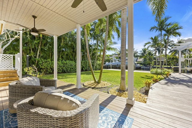 wooden deck with ceiling fan and a lawn