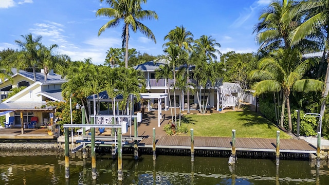 dock area with a water view, a balcony, and a lawn