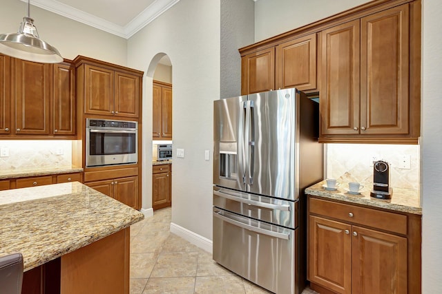 kitchen with pendant lighting, backsplash, light stone countertops, appliances with stainless steel finishes, and light tile patterned flooring