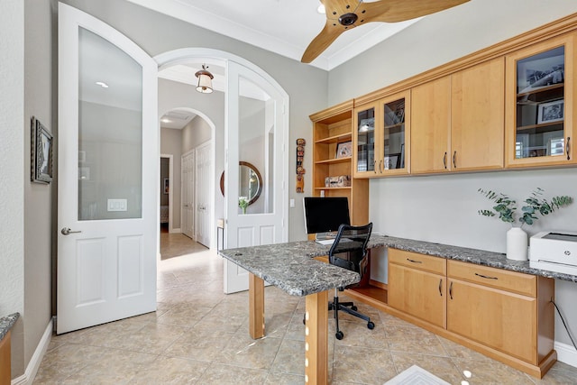 tiled office with ceiling fan, crown molding, and built in desk