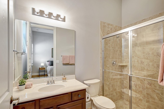 bathroom featuring vanity, toilet, and an enclosed shower