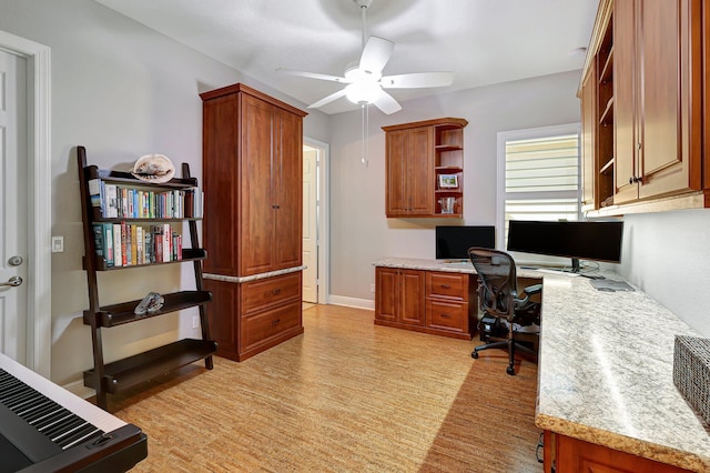 office featuring ceiling fan, built in desk, and light hardwood / wood-style flooring