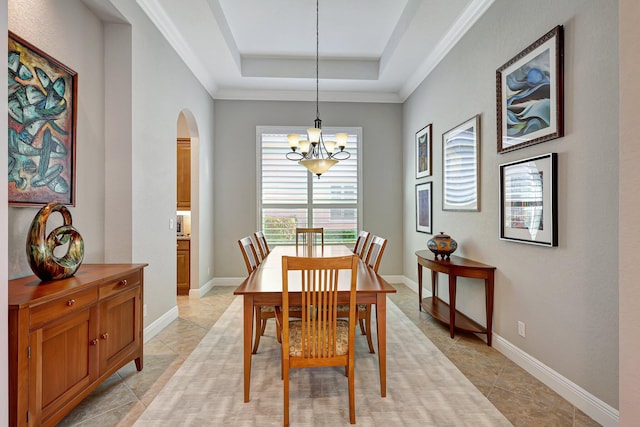 dining area featuring a raised ceiling, crown molding, and a notable chandelier