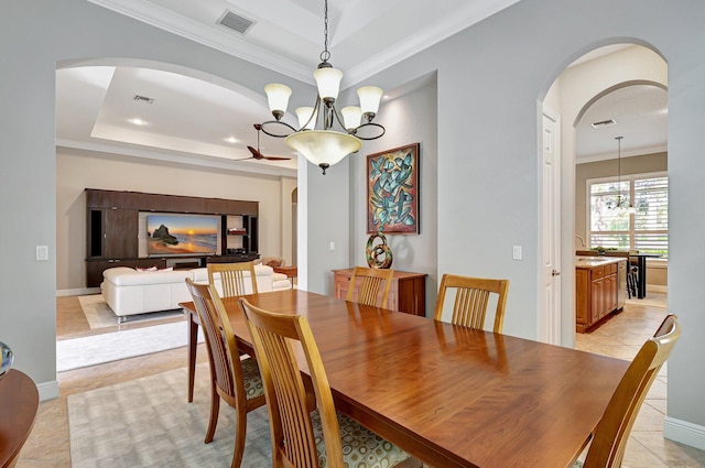 tiled dining room with ornamental molding, sink, a tray ceiling, and a chandelier