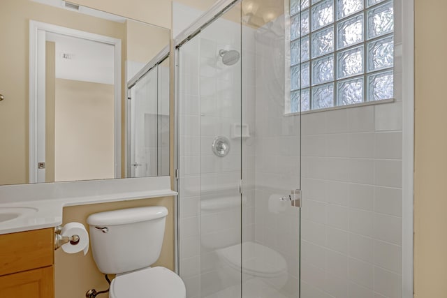 bathroom with vanity, toilet, and a shower with shower door