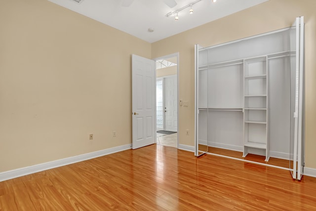 unfurnished bedroom with ceiling fan, light hardwood / wood-style floors, and a closet