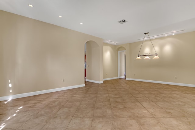 unfurnished room with light tile patterned floors and track lighting