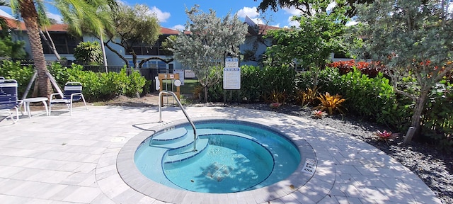 view of swimming pool with a patio and a hot tub