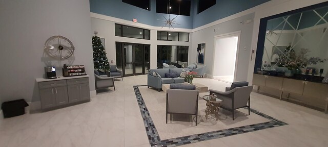 interior space with ceiling fan, dark carpet, and a drop ceiling