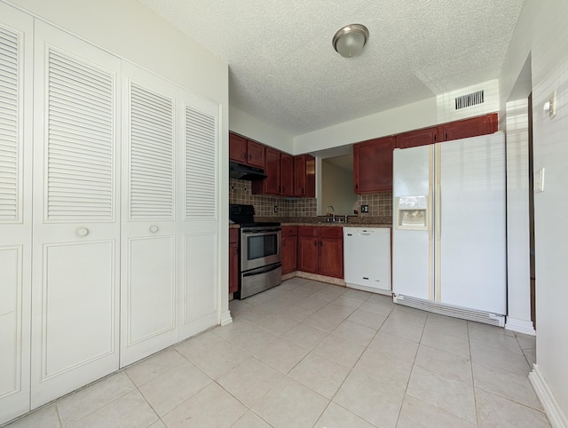 kitchen with visible vents, dark brown cabinets, backsplash, under cabinet range hood, and white appliances