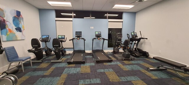 workout area featuring a paneled ceiling and ceiling fan