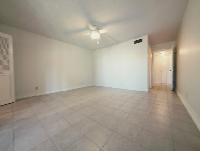 tiled spare room with ceiling fan