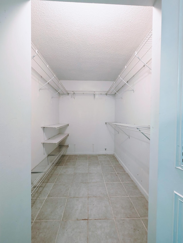 walk in closet with tile patterned floors