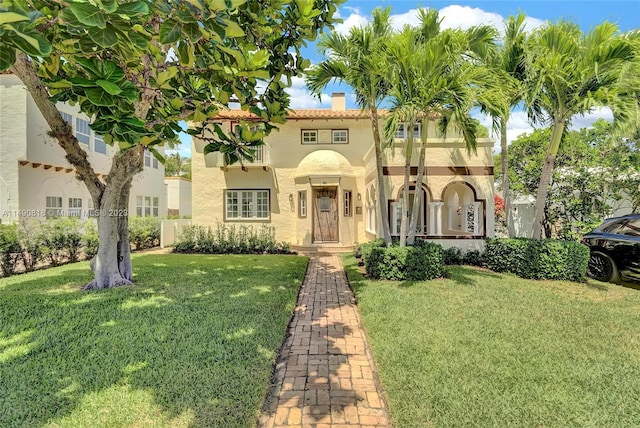 mediterranean / spanish home featuring a front lawn