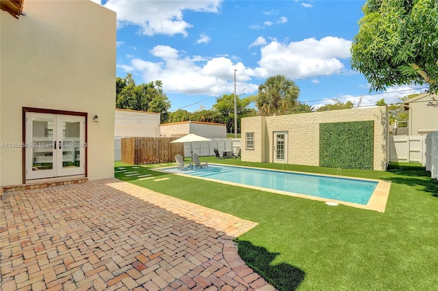 view of swimming pool with a lawn, a patio area, and french doors