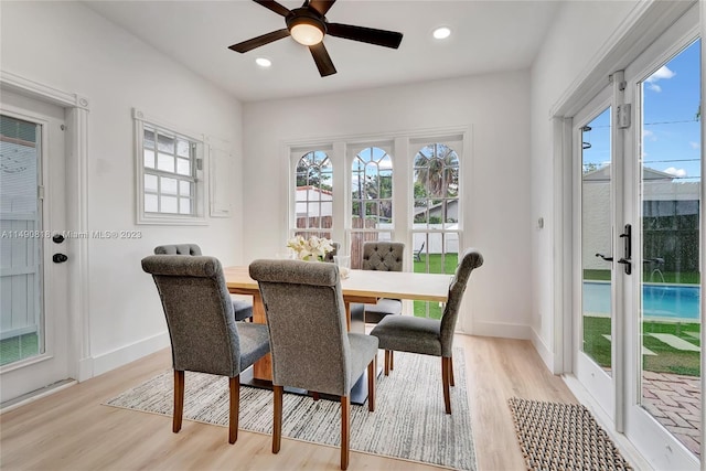 dining room with light wood-type flooring, ceiling fan, and a healthy amount of sunlight