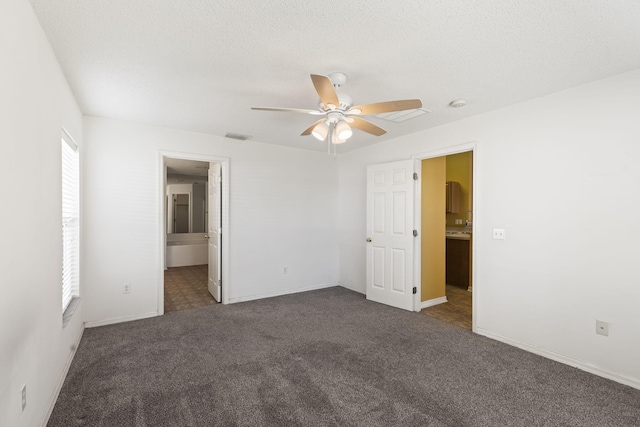 carpeted spare room featuring ceiling fan and a textured ceiling