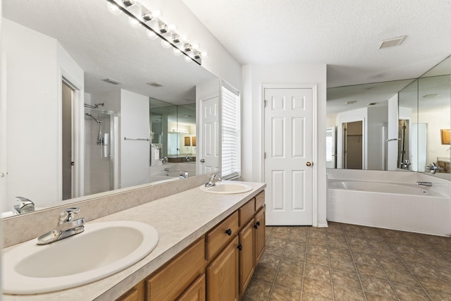 bathroom with vanity, a textured ceiling, and plus walk in shower