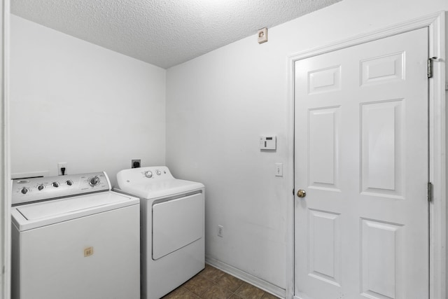 laundry room featuring washer and clothes dryer and a textured ceiling