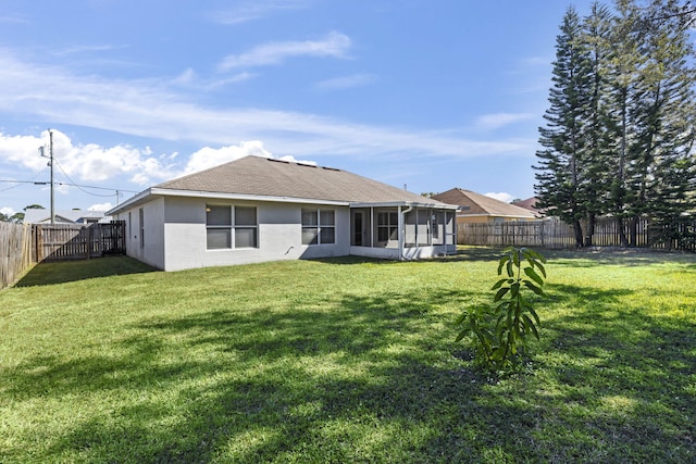 rear view of property with a lawn and a sunroom