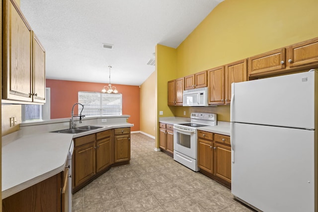 kitchen featuring white appliances, sink, vaulted ceiling, decorative light fixtures, and a chandelier