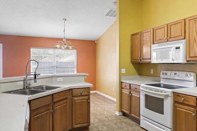 kitchen with sink, hanging light fixtures, an inviting chandelier, a textured ceiling, and white appliances