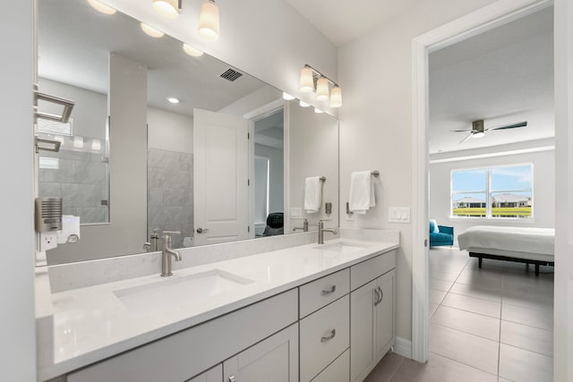 bathroom featuring tiled shower, vanity, tile patterned floors, and ceiling fan