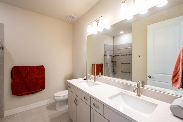 bathroom with tile patterned flooring, vanity, toilet, and tiled shower