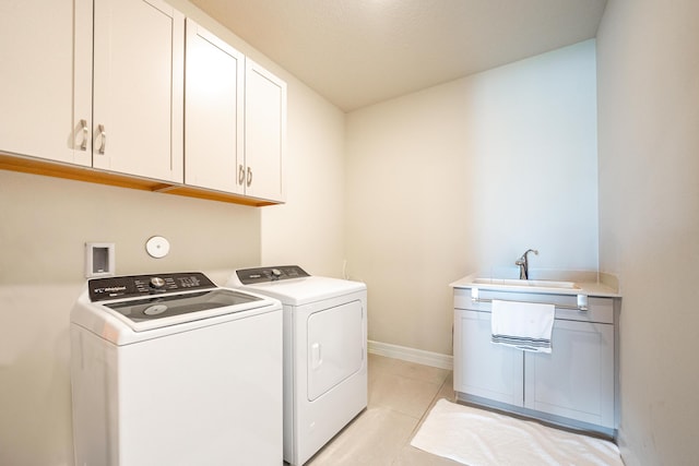 washroom featuring cabinets, independent washer and dryer, sink, and light tile patterned floors