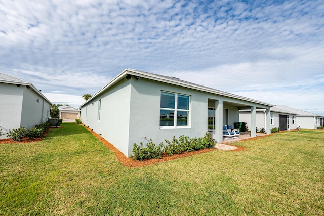 view of side of property with a yard and a patio area