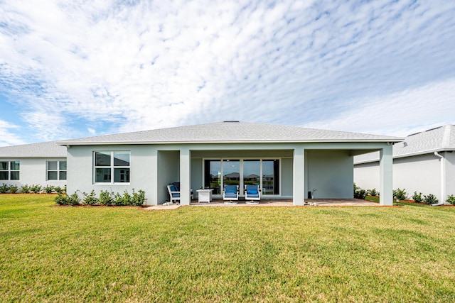 rear view of house with a yard and a patio