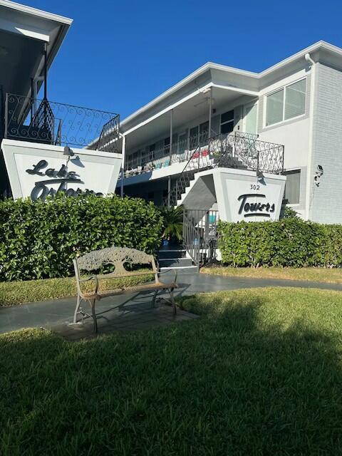 302 Lake Osborne Dr Unit 19, Lake Worth, FL 33461 - rear view of property featuring stairway, a yard, and a balcony