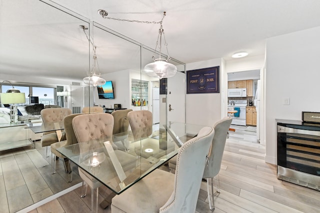 dining space featuring light hardwood / wood-style floors and wine cooler